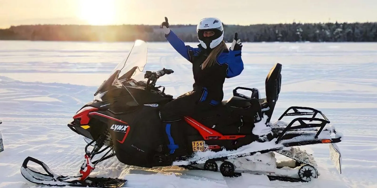 Rider steering a new 2025 snowmobile along a snowy forest trail near Rovaniemi