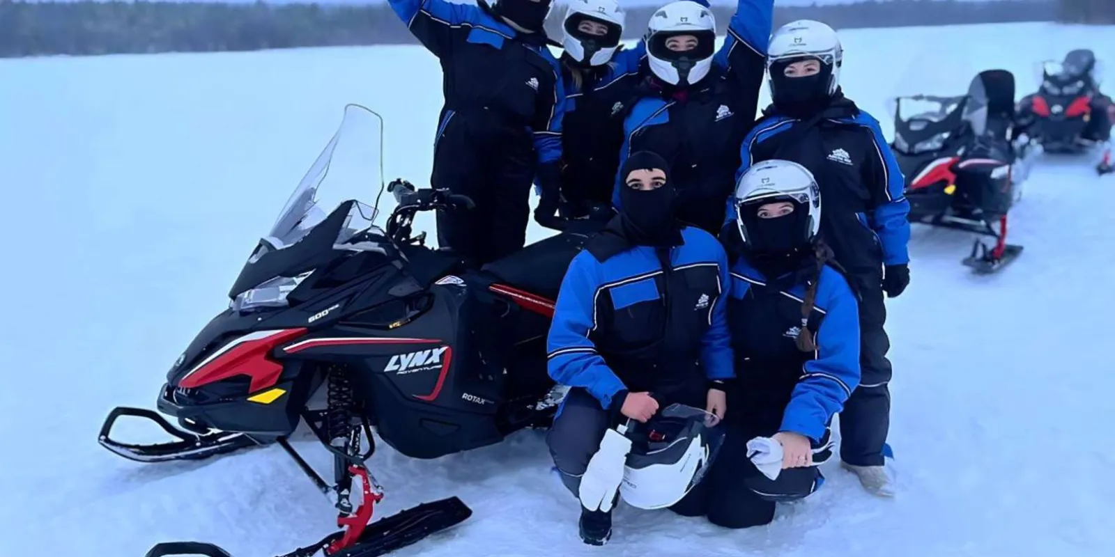 Line of snowmobiles crossing open Arctic tundra on a guided safari