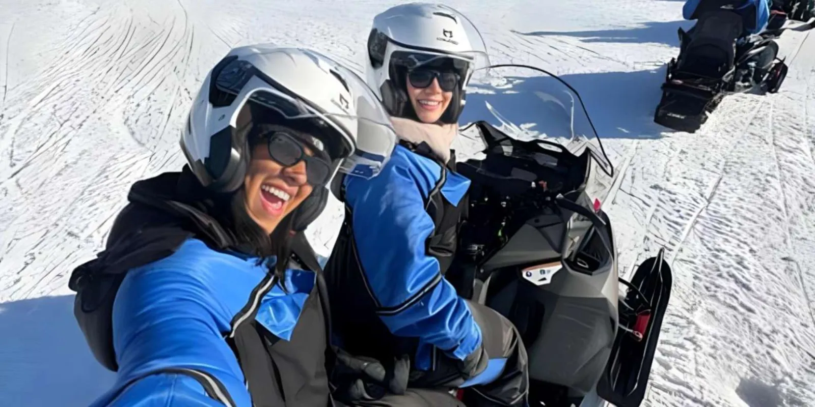 Snowmobiler pausing among snow-laden pines in Lapland