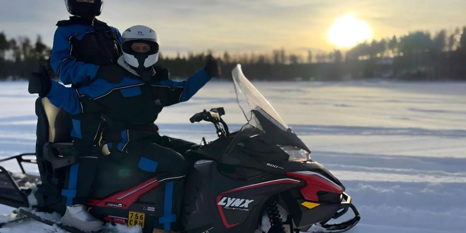 Guest in thermal gear driving a snowmobile through Arctic wilderness